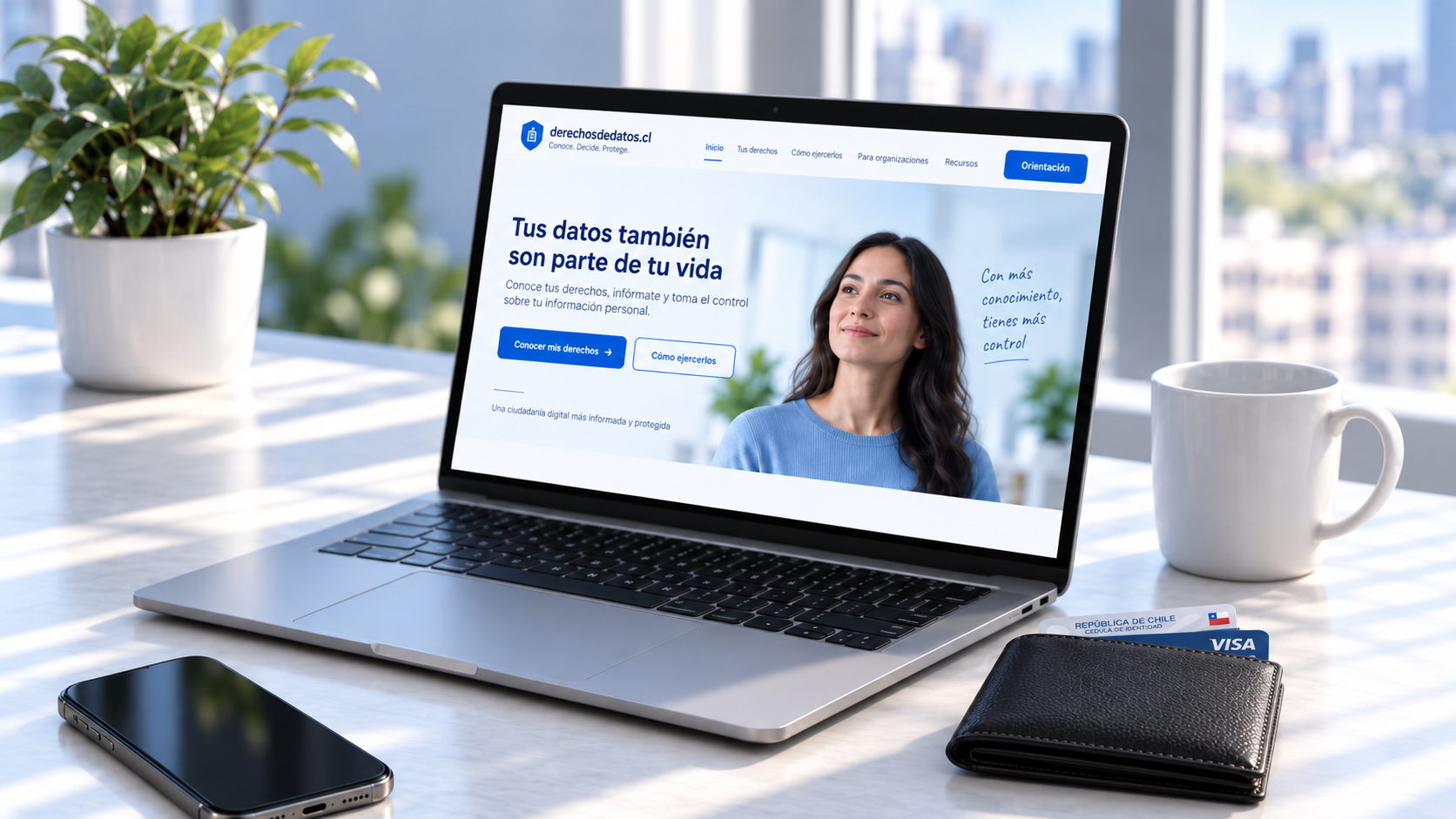 Computador con derechosdedatos.cl, teléfono y billetera sobre un escritorio